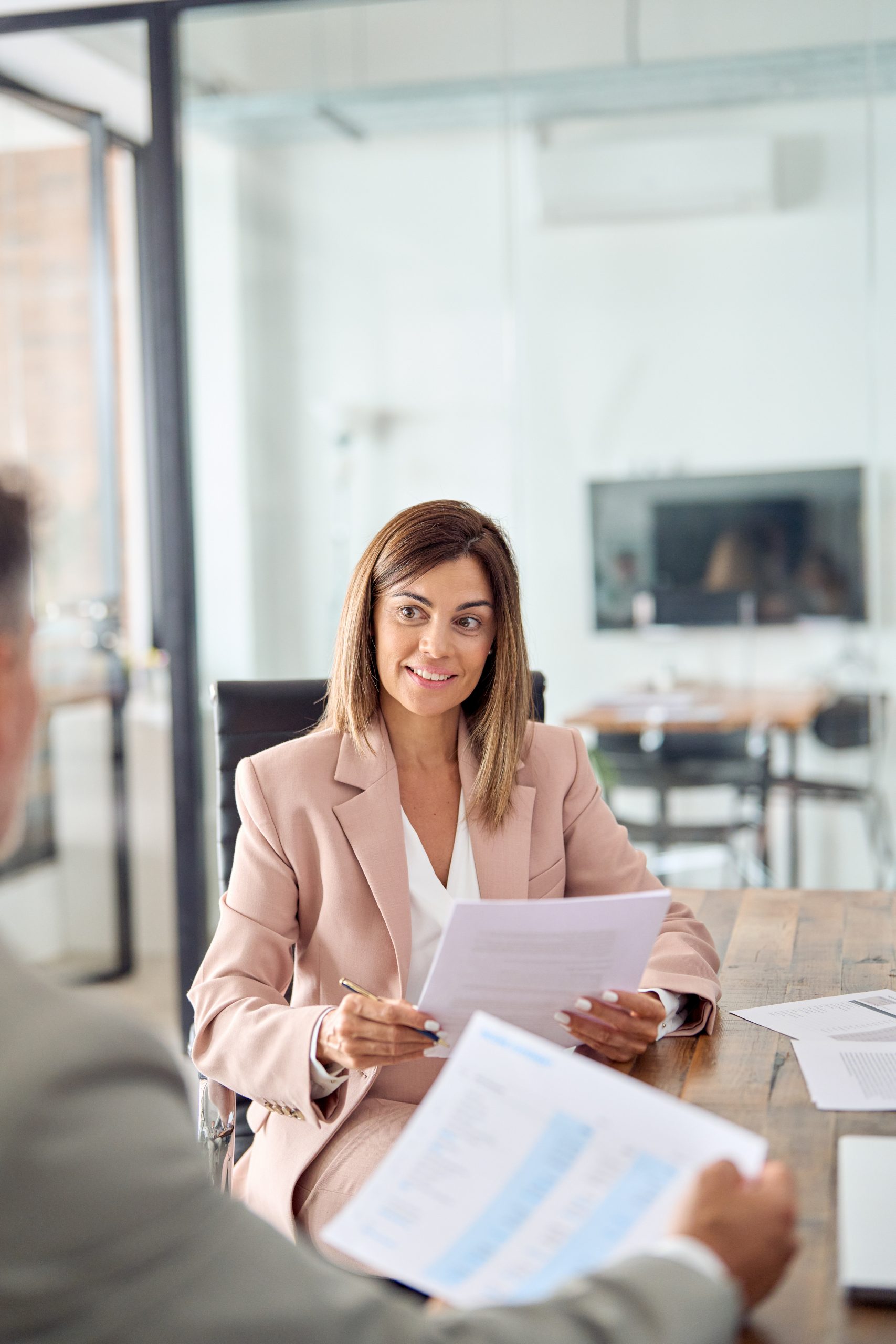 Mature business woman manager holding documents at office meeting.